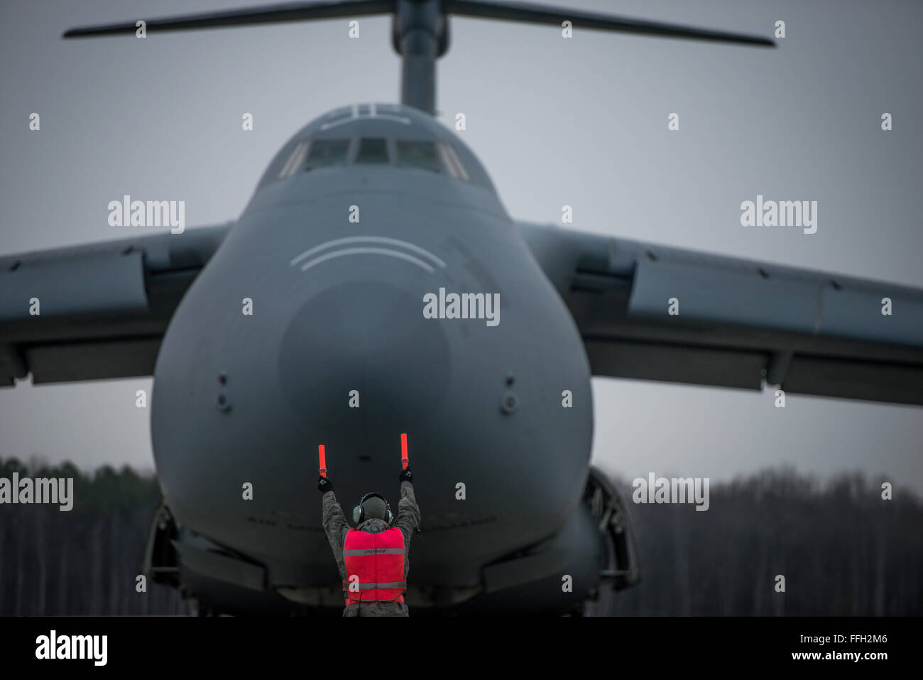 Ein Flieger mit der 436th Aircraft Maintenance Squadron Marschälle eine c-5 Galaxy in die richtige Parkposition, nachdem es von einer Mission auf der Dover Air Force Base, Delaware gelandet. Stockfoto