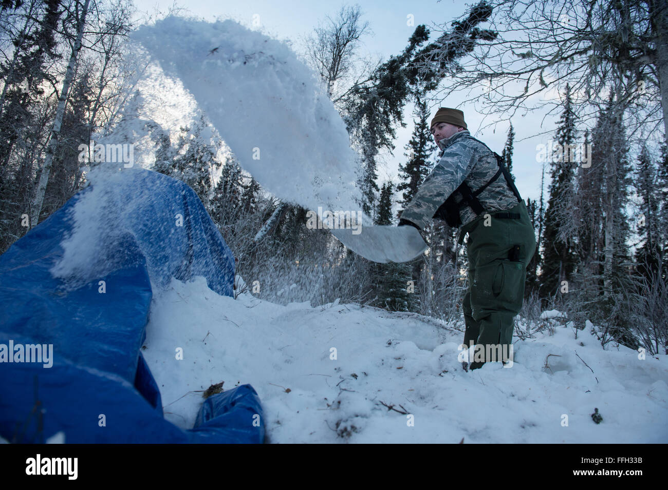 Capt Bart Spendley, 274th Air Support Betrieb Squadron, Luft-Verbindungsoffizier, wirft Schnee um eine a-förmige Unterschlupf bei arktischen Überlebende training zu erstellen. A-Frame Tierheim soll die Überlebende halten warm und trocken, raue Arktische Nächte zu ertragen. Der Kurs ist fünf Tage in der Dauer mit Unterricht in Einarbeitung in die arktische Umwelt, Medizin, Personenschutz, Nahrung und Signalisierung. Stockfoto