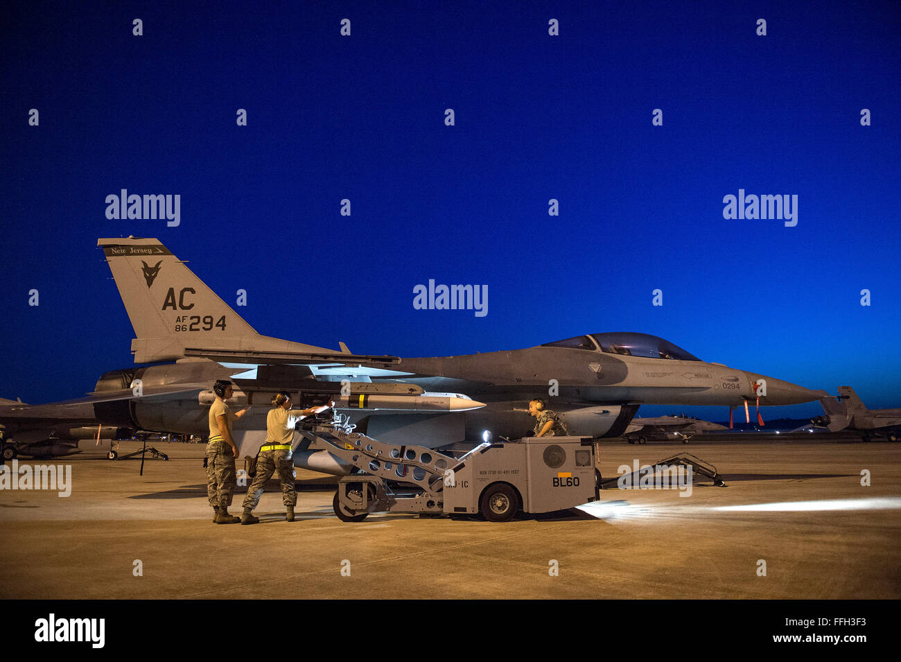 Laden Sie eine Luft-Luft-Rakete AIM-120 auf f-16 Fighting Falcon, Senior Airman Vincent Avallone (left) Staff Sgt. Kelly Eilenberg und Senior Airman Jonathan Bybee von 177 Kämpfer-Flügel, New Jersey Air National Guard. Die 177. ist Tyndall Air Force Base Teilnahme an Übung Archer zu bekämpfen. Stockfoto