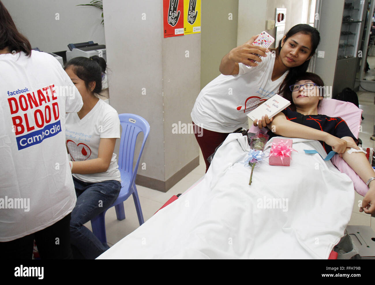 Phnom Penh, Kambodscha. 14. Februar 2016. Eine junge Frau nimmt ein Selbstporträt mit ihrer Freundin, der Blut in Phnom Penh, Kambodscha, 14. Februar 2016 spendet. Die Kambodscha nationaler Bluttransfusion Center (NBTC) erfasst etwa 600 Einheiten Blut am Sonntag während seiner dritten jährlichen Valentinstag Blutspendeaktion. Bildnachweis: Sovannara/Xinhua/Alamy Live-Nachrichten Stockfoto