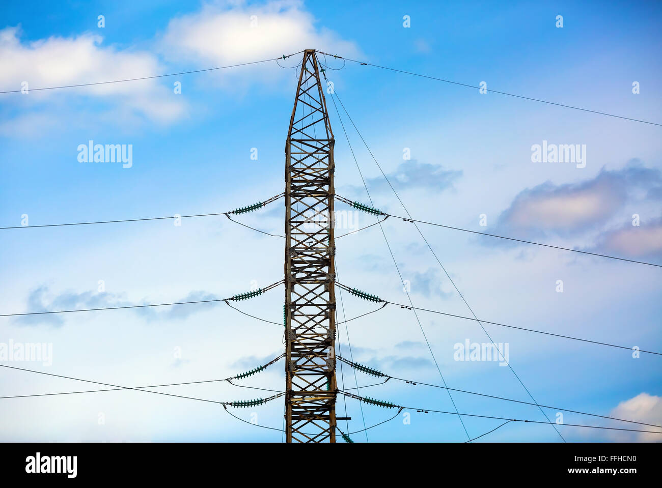 Strommast vor blauem Himmelshintergrund abhebt. Hochspannungs-Turm. Elektrischen Leitungen. Stockfoto