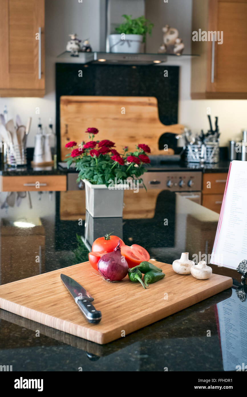 Zubereitung von Speisen in der heimischen Küche mit einem chopping Board, Messer und Rezept-Buch Stockfoto