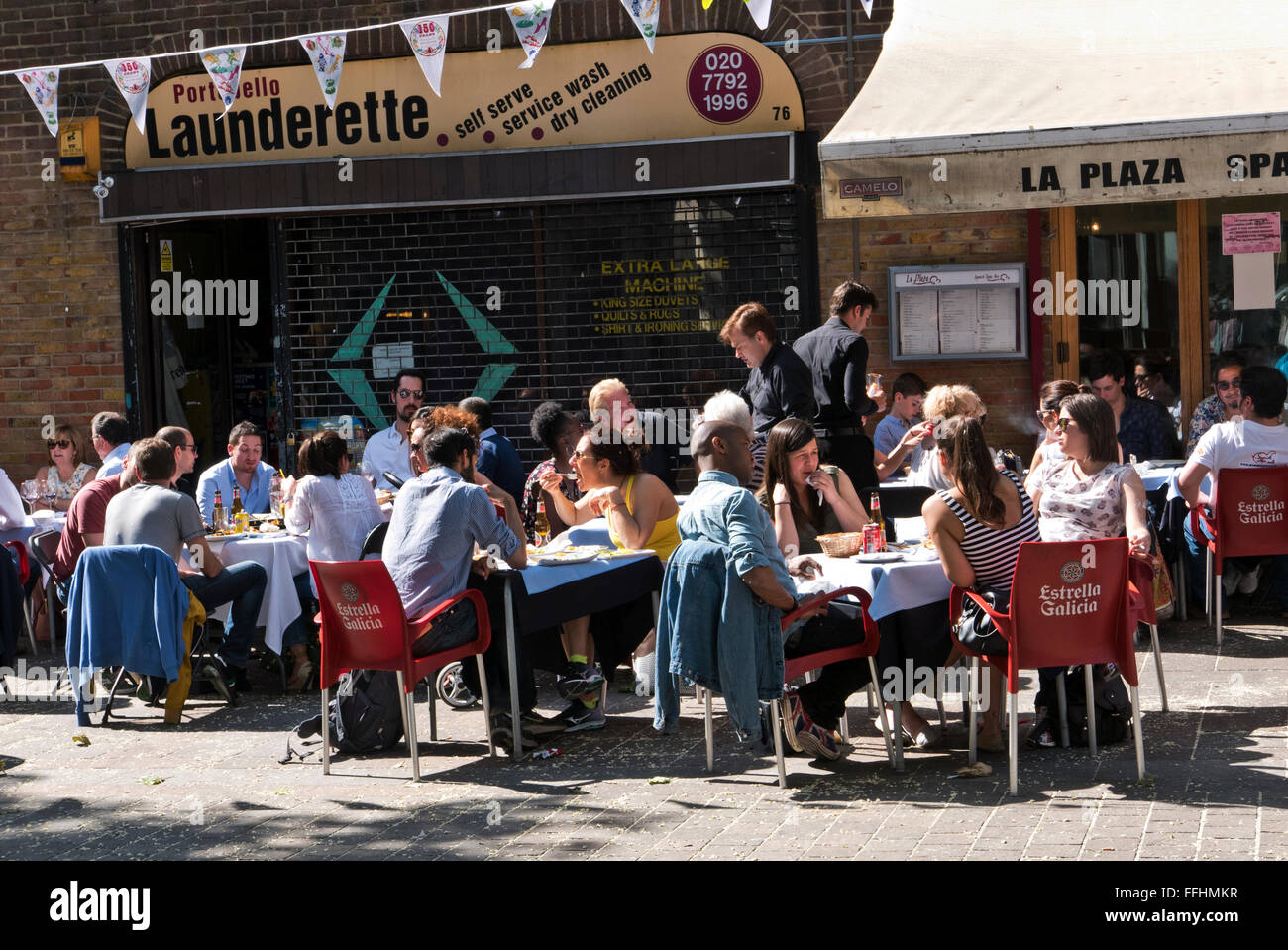 Menschen sitzen vor einem Restaurant in Notting Hill Gate in London, Vereinigtes Königreich. Stockfoto