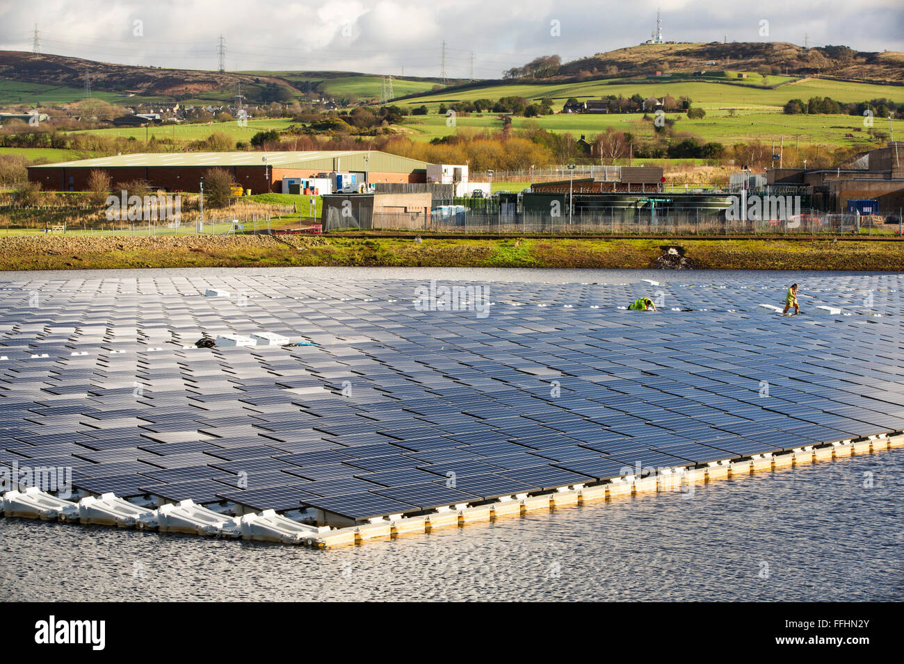 Die neue schwimmende solare Farm als Raster verbunden Godley Reservoir in Hyde, Manchester, UK. Das Schema ist ein 3-MW-System, bestehend aus 10.000 Photovoltaik-Paneele. Es wird United Utilities Stromrechnung auf der Kläranlage vor Ort, rund 7.000 £ pro Monat einsparen. Es ist die größte schwimmende solar Farm in Europa und der zweitgrößte in der Welt. Es liefert rund 33 % der Wasseraufbereitung Energiebedarf Pflanzen. Stockfoto