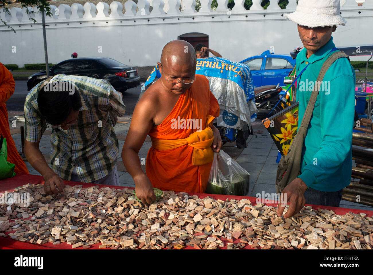 Buddhistischer Mönch und weitere Personen, die ein Amulette, Periapts zu kaufen. Amulett-Markt. Bangkok. Buddhistische Mönche gesehen betrachtet man schützende ein Stockfoto