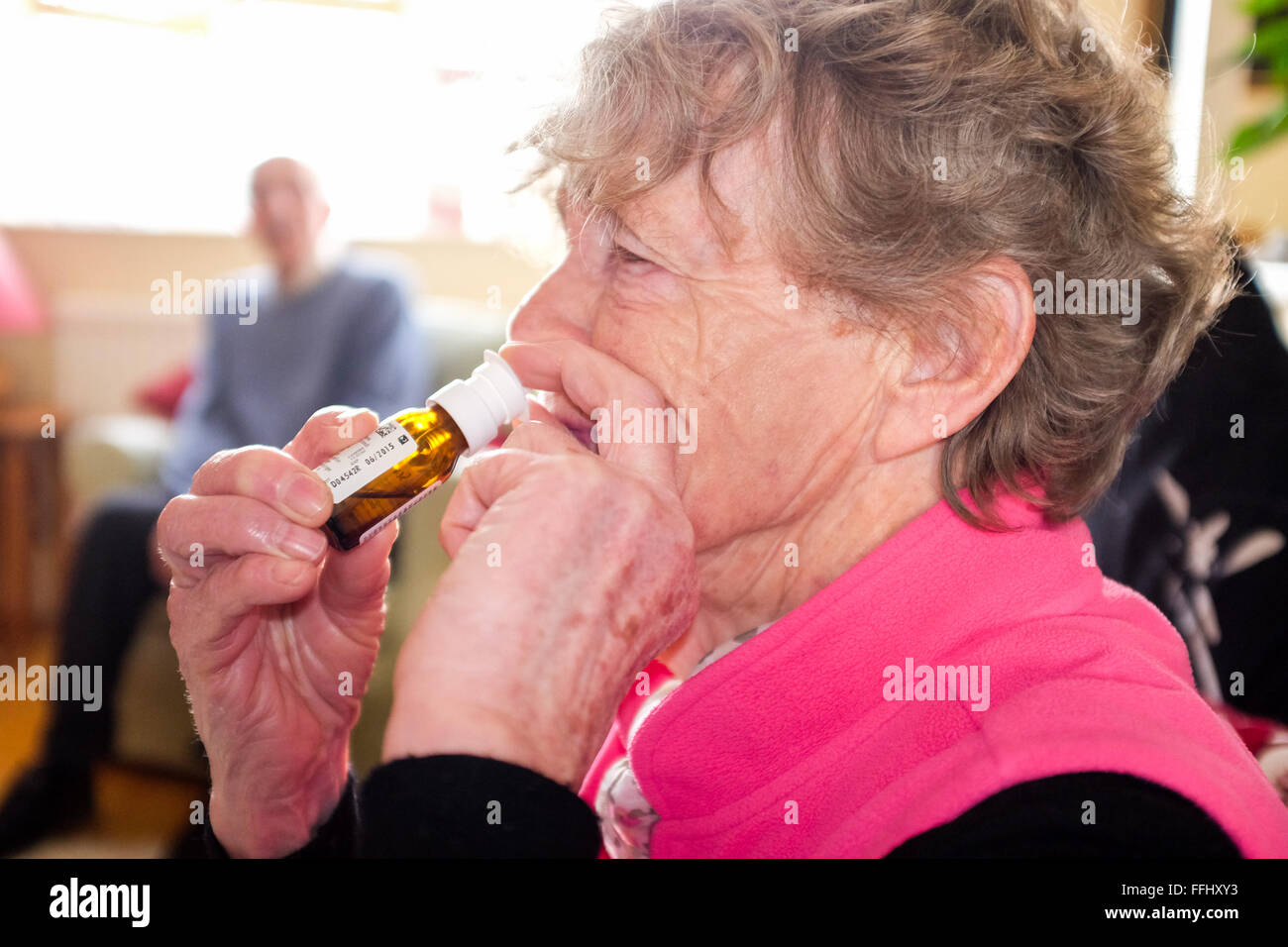 Ältere Frau mit einem Nasenspray um zu helfen, mit verstopfter Nase und Nasennebenhöhlen Stockfoto