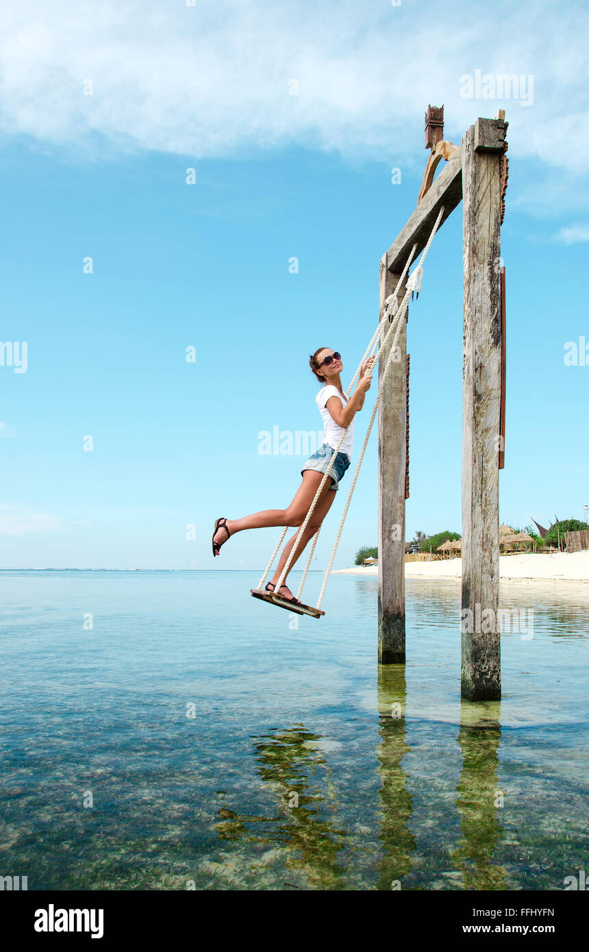Bali, Indonesien. Am Strand eine junge schöne Mädchen auf einer Schaukel im  Meer reiten. Stock Bild Stockfotografie - Alamy
