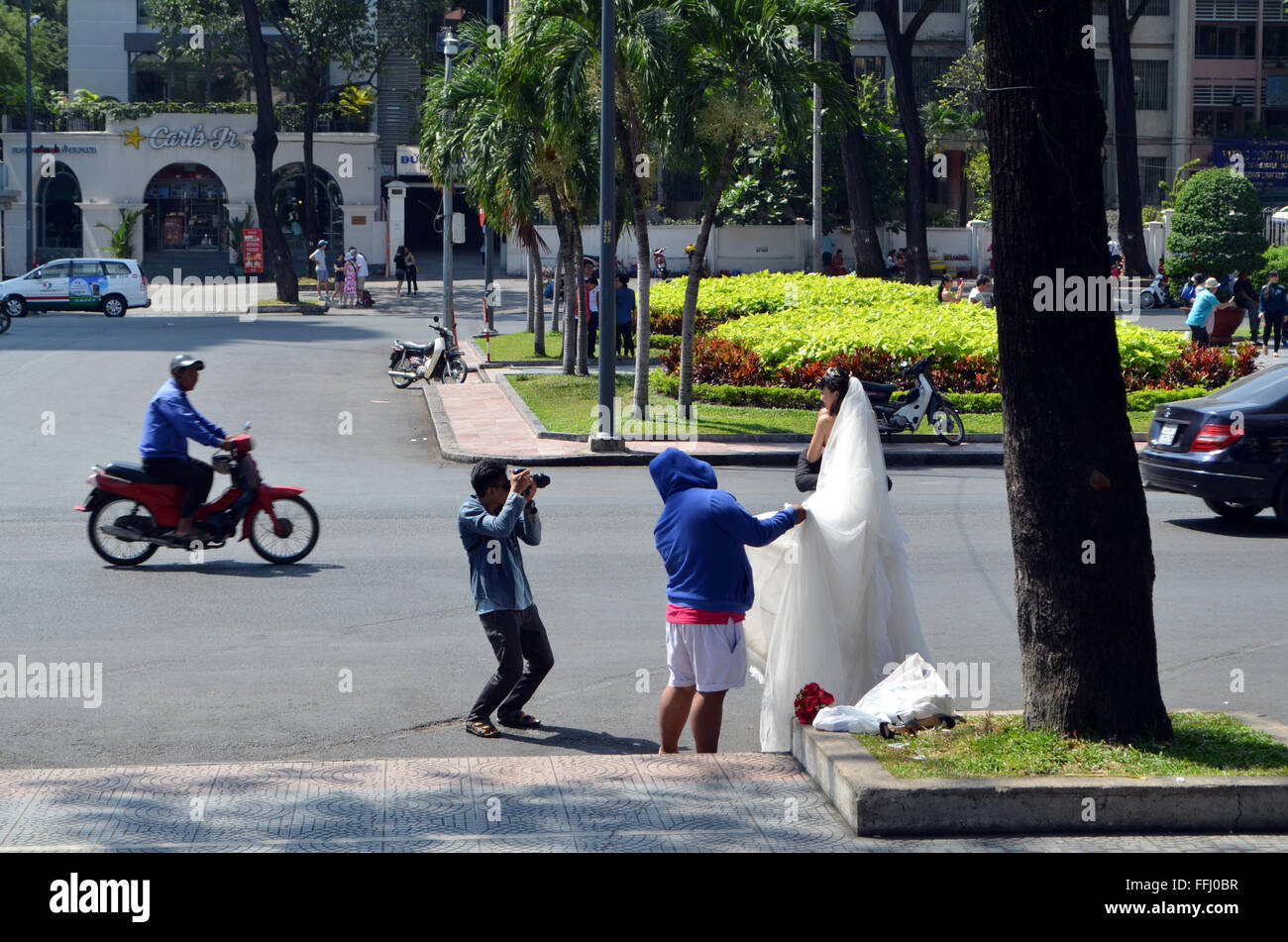 Eine Braut ist vor der Kathedrale auf der Straße, eine ungewöhnliche Kulisse für ihre Hochzeitsfotos zu machen gestellt. Stockfoto