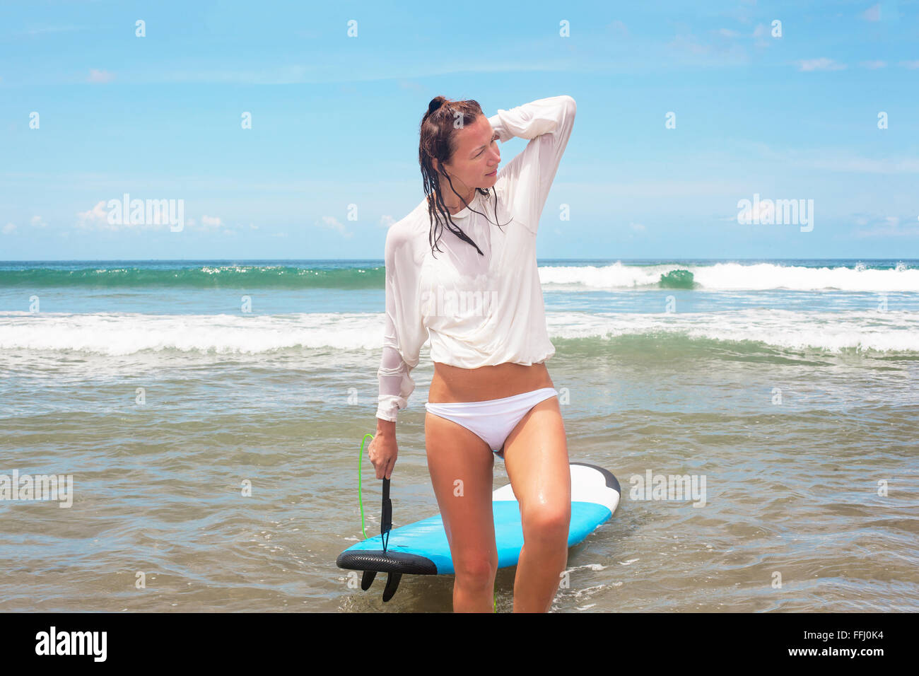 Mädchen auf den Wellen im Ozean mit ihrem Surfbrett. Stock Bild Stockfoto