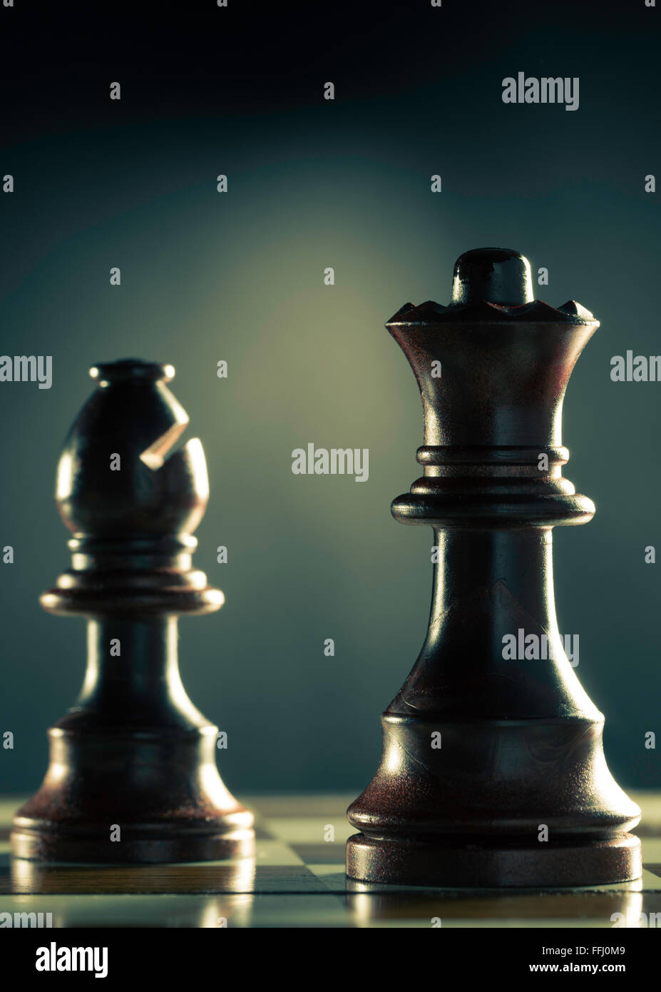 Vertikales Bild von einem Schachspiel mit Fokus auf die Königin auf dunklem Hintergrund, Konzept Management oder Business Vorfreude. Stockfoto