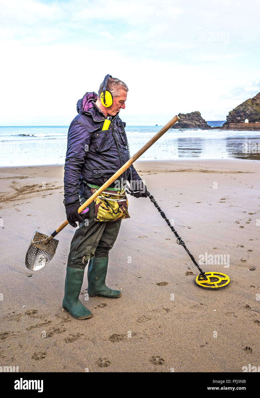Mann mit einem Metalldetektor auf Portreath Strand in Cornwall, Großbritannien Stockfoto
