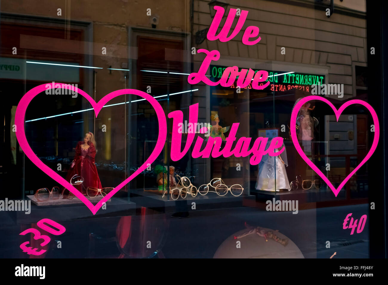 Wir lieben Shopping-Schild auf einer Brille Schaufenster. Optiker Laden vor. Florenz, Toskana, Mittelitalien, Europa, Europäische Union, EU. Stockfoto