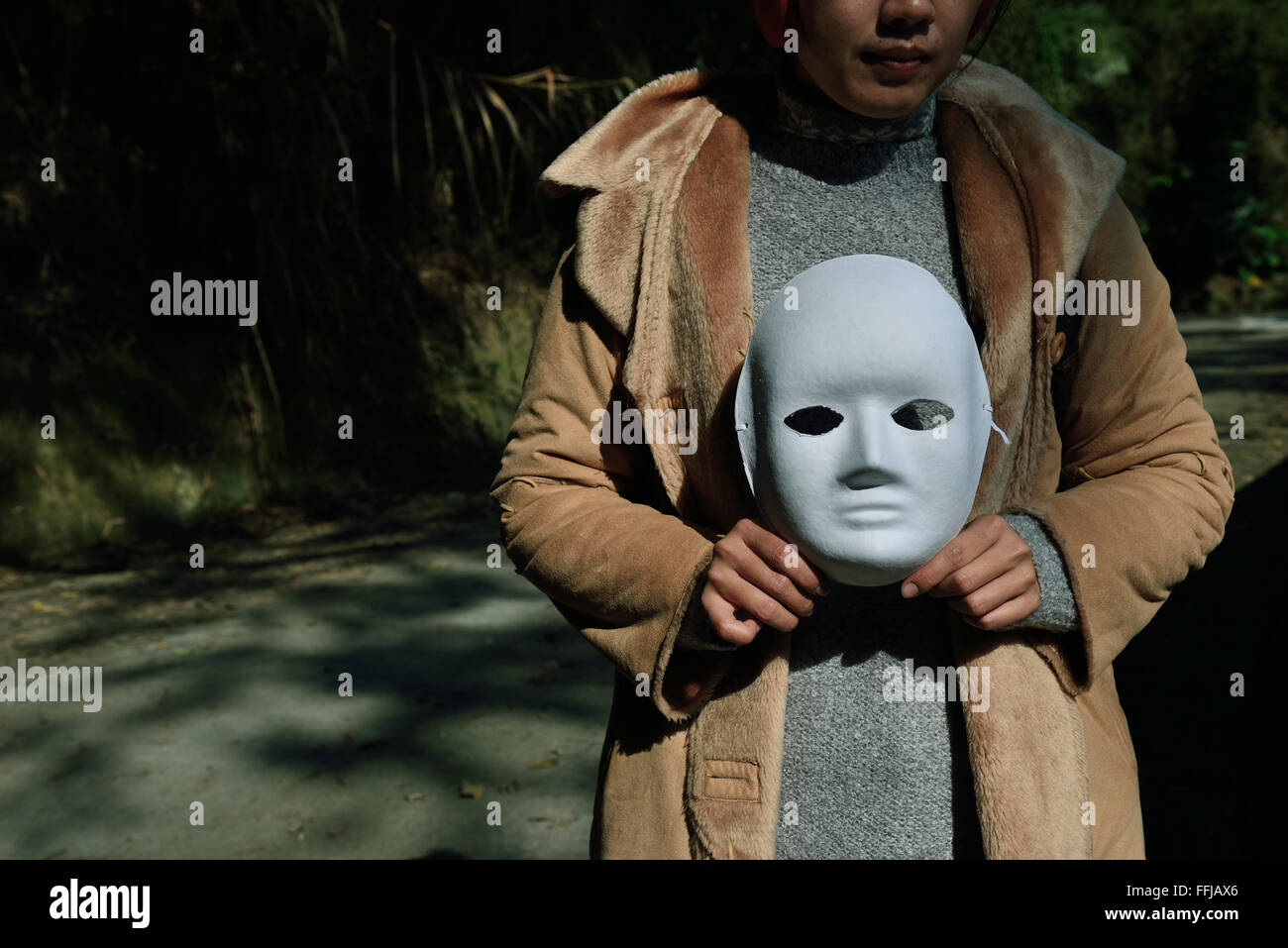 Frau nehmen eine Maske Stockfoto