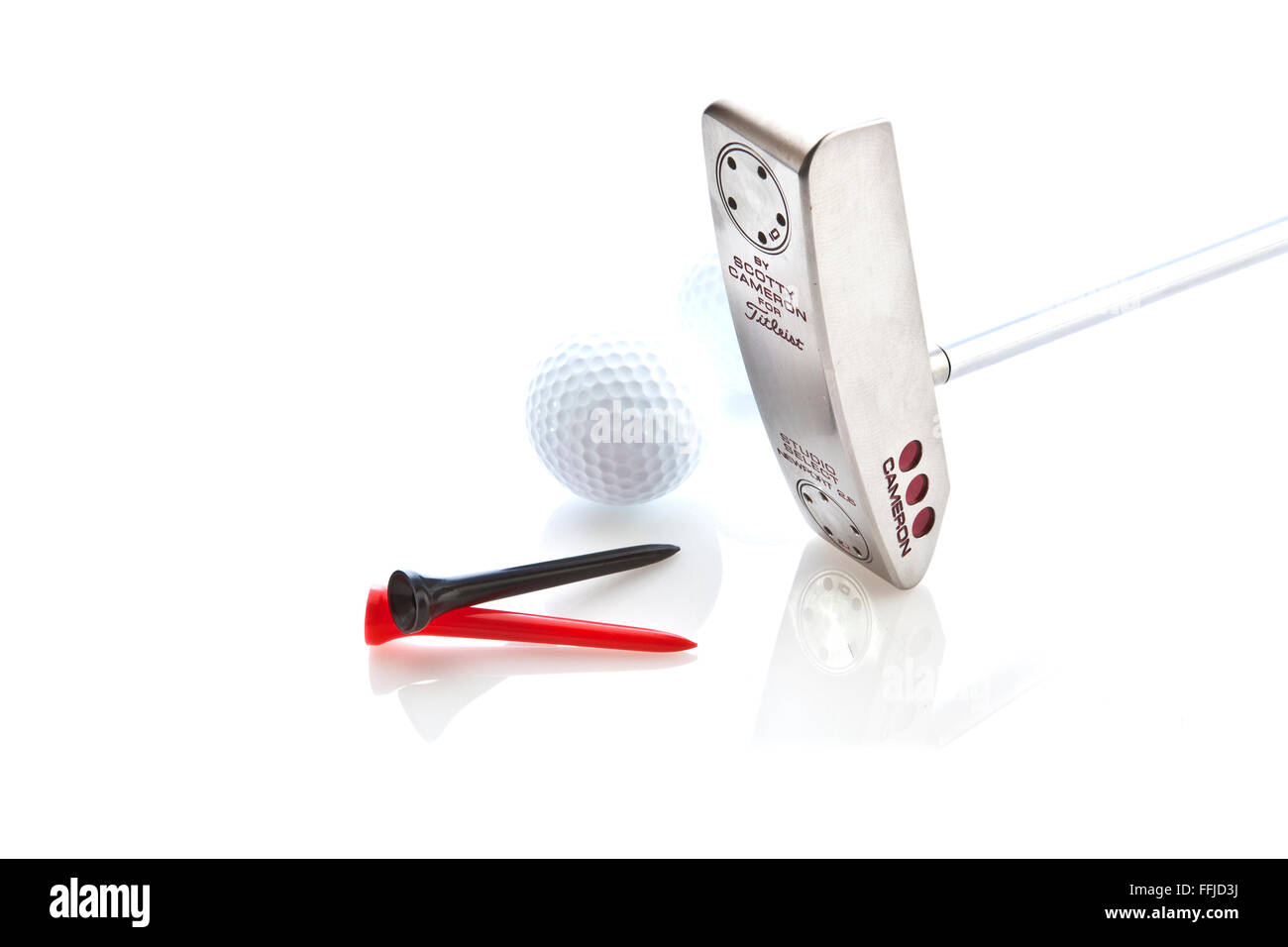 Scotty Cameron Putter mit Golfball und Tees auf weißem Hintergrund Stockfoto