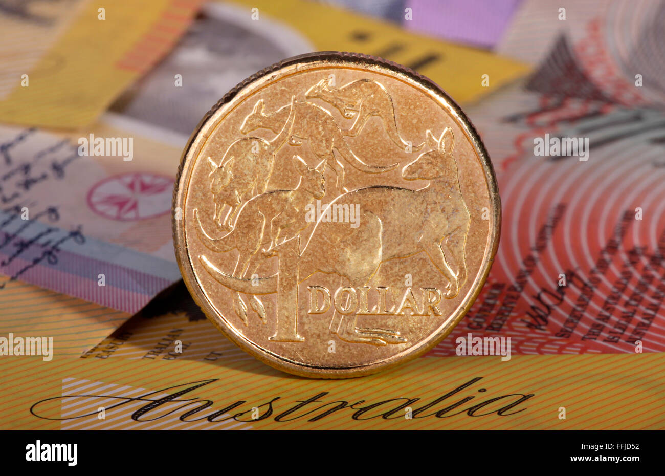 Eine australische Dollar-Münze mit einem Hintergrund von australischen Banknoten. Stockfoto
