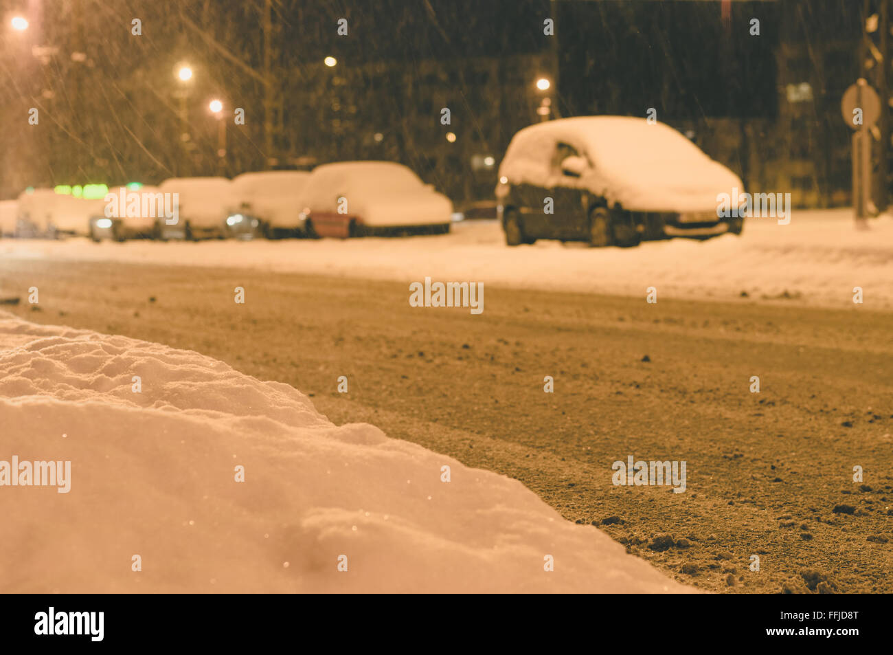 Schneefall in Stadt, verschneiten am Straßenrand Parken bei Nacht Stockfoto