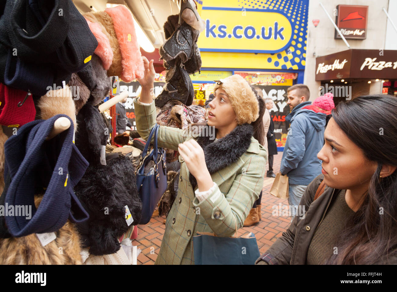 Zwei junge Frauen, Kauf von Kleidung an einem Marktstand, Birmingham UK Stockfoto