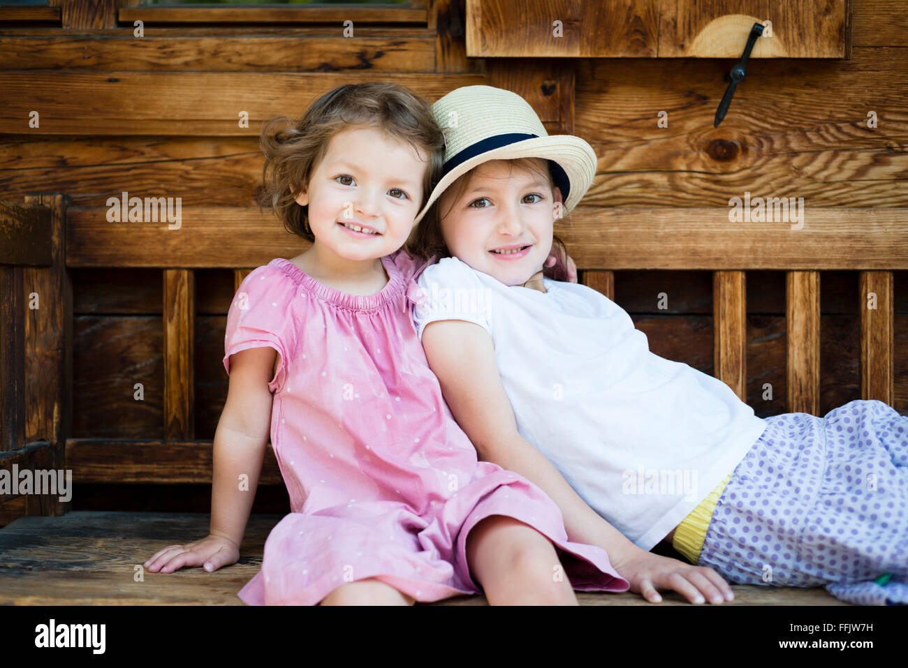 Porträt von zwei kleinen Mädchen auf Bank Stockfoto