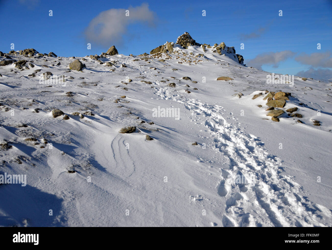 Fußspuren im Schnee zu den Gipfel Cairn Wirbel wie im Winter Stockfoto