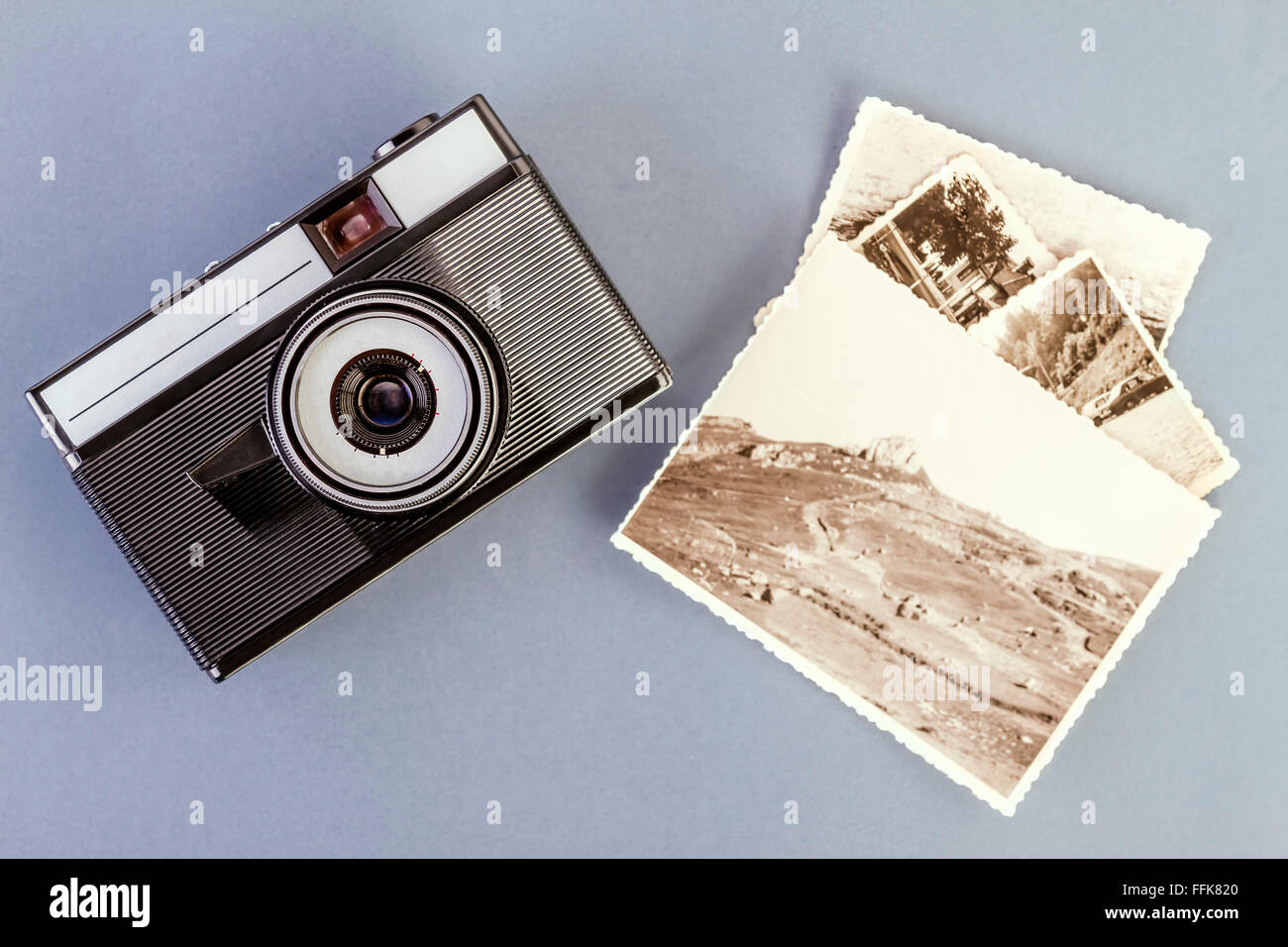 Vintage Foto-Kamera und alte Fotos auf einem grauen Tisch Stockfoto