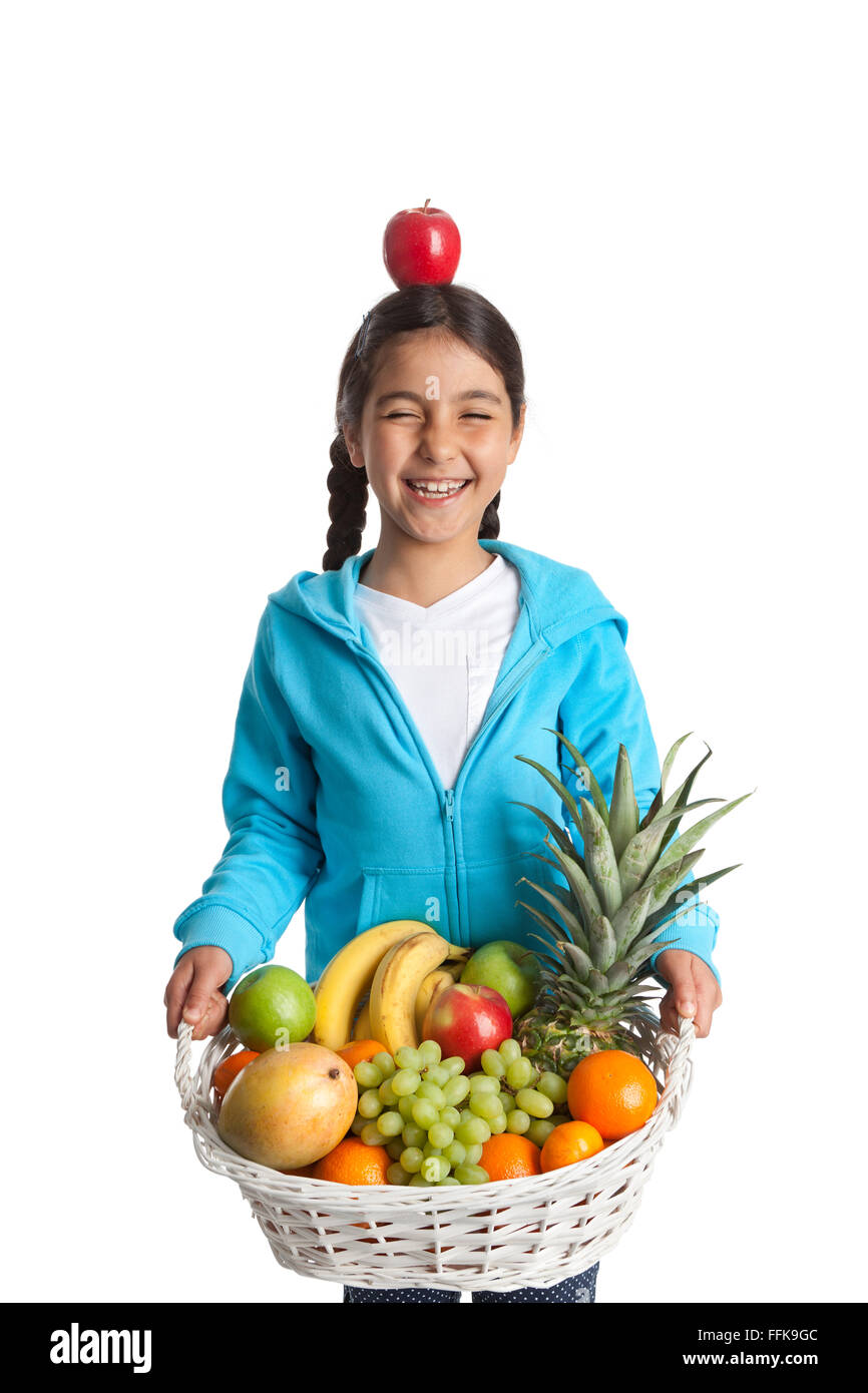 Lachende Mädchen tragen einen Obstkorb mit einem Apfel auf dem Kopf auf weißem Hintergrund Stockfoto