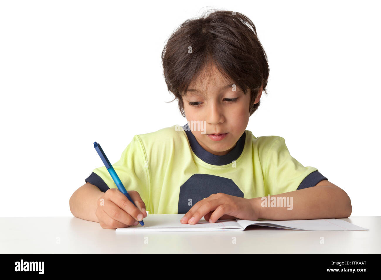 Kleiner Junge schreibt in seinem Notizbuch auf weißem Hintergrund Stockfoto