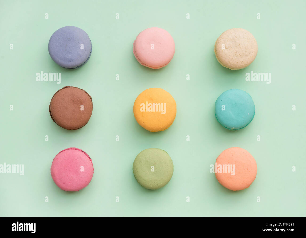Süße bunte französische Makronen Kekse auf Pastell Mint Hintergrund, Ansicht von oben Stockfoto