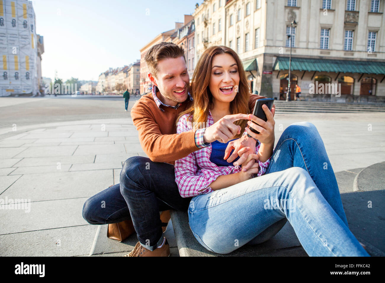 Mitte erwachsenes paar auf einer Städtereise mit Smartphone Stockfoto
