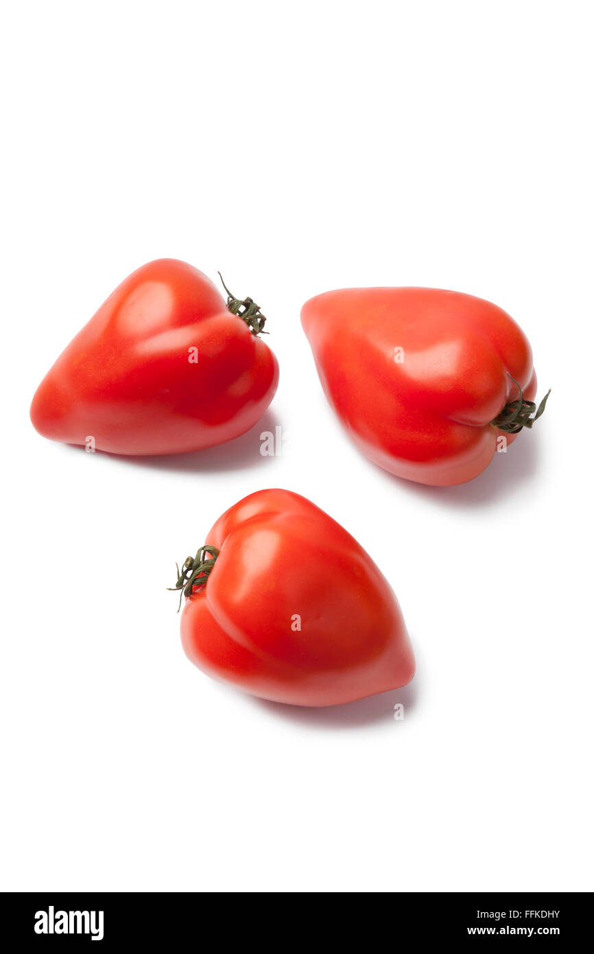 Gesamte französische Tomaten in Herzform auf weißem Hintergrund Stockfoto