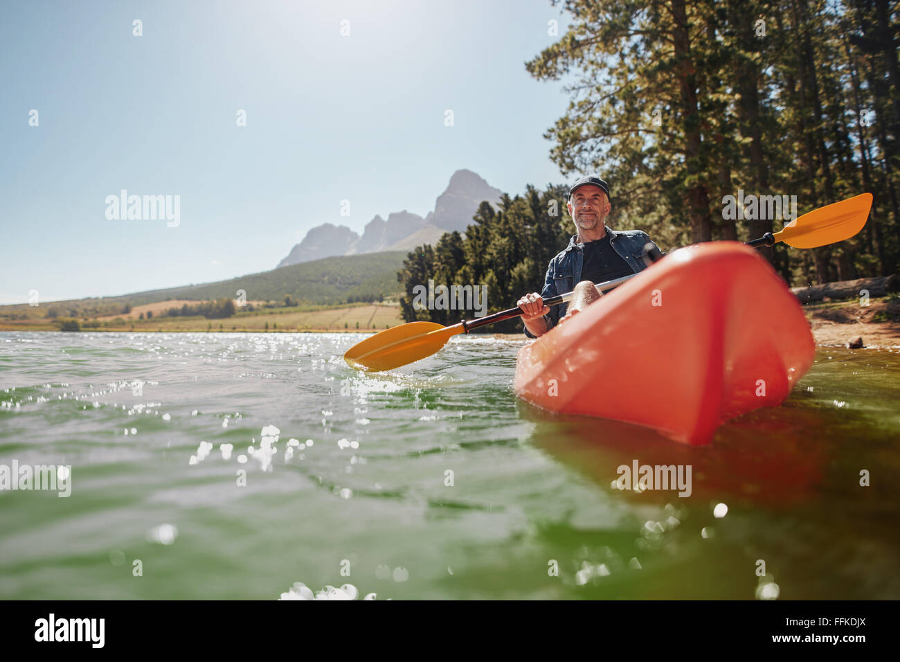 Rückansicht eines senior Mannes an einem sonnigen Tag in einem See paddeln. Senior woman paddeln Kajak. Stockfoto