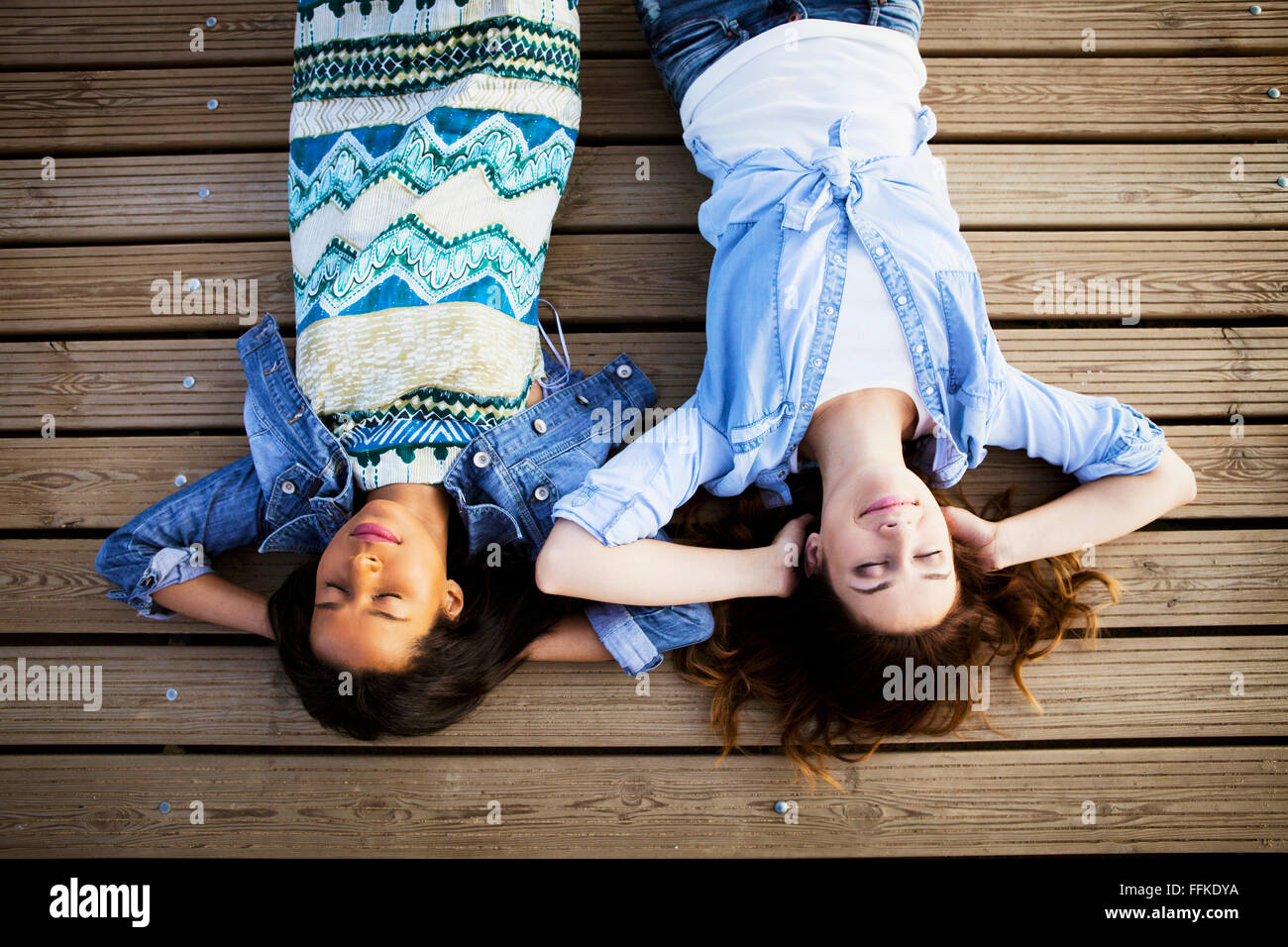 Zwei Frauen auf Rücken liegend mit Augen geschlossen Stockfoto
