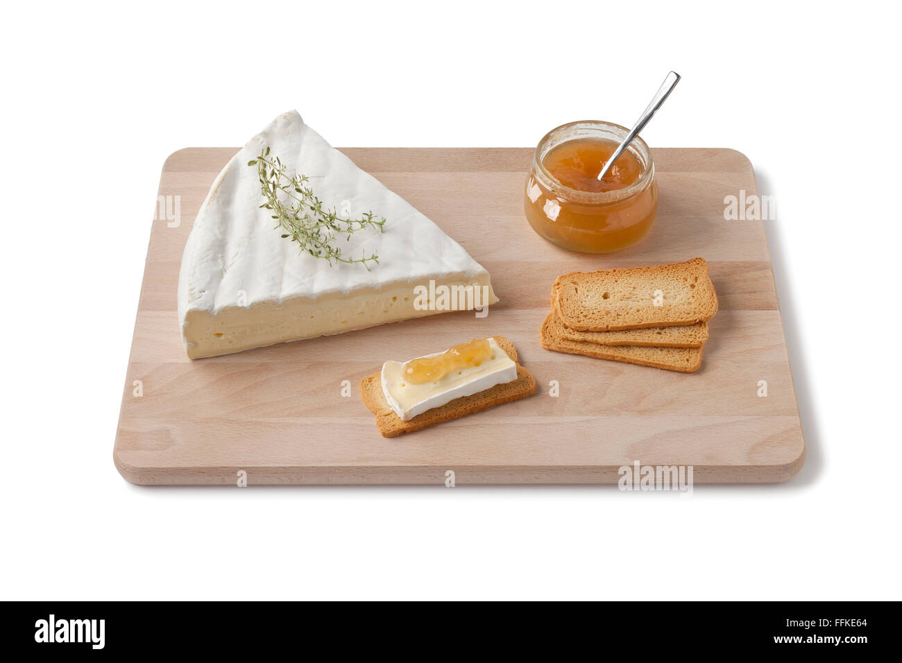 Brie Käse mit Thymian, Toast und Obst Sauce als Dessert auf einem Holzbrett auf weißem Hintergrund Stockfoto