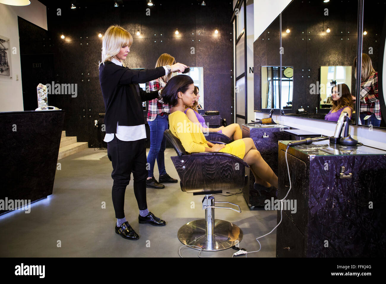 Friseur Bürsten Haare des Kunden im Friseursalon Stockfoto