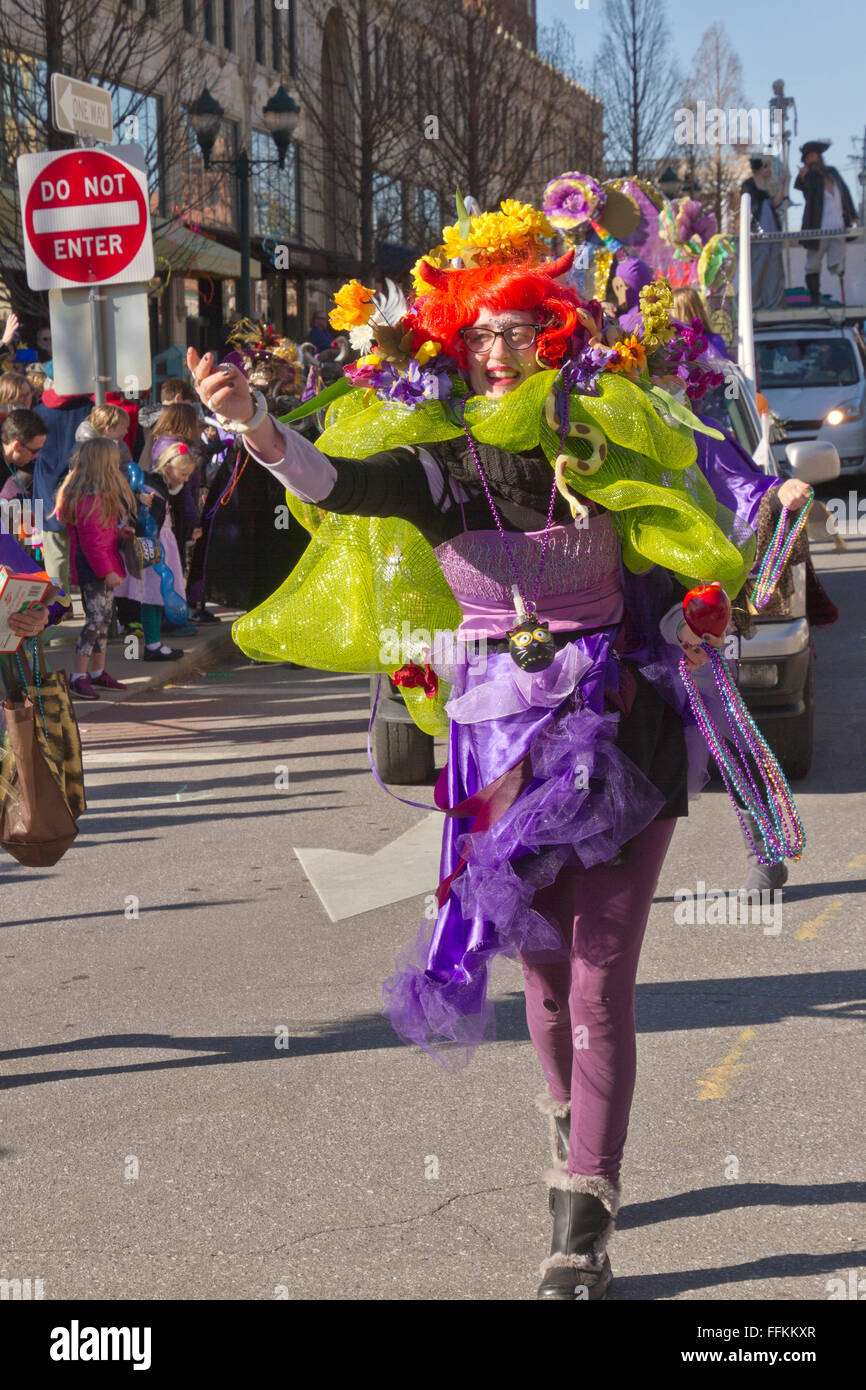 Eine bunt kostümierte Frau in eine Karneval Parade wirft bunte Kunststoff-Perlen für die Zuschauer Stockfoto