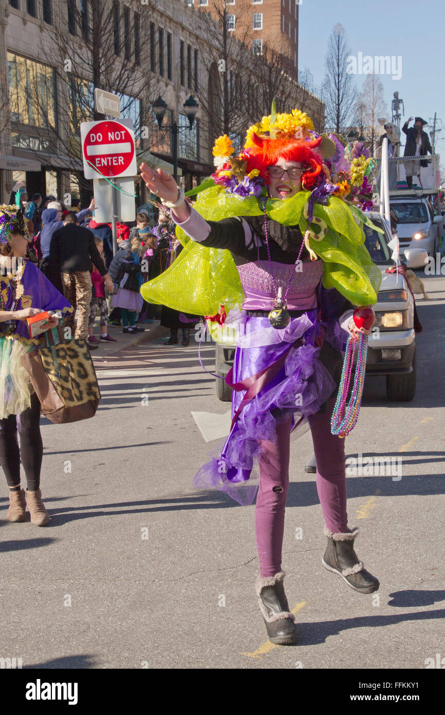 Eine bunt kostümierte Frau in eine Karneval Parade wirft bunte Kunststoff-Perlen für die Zuschauer Stockfoto