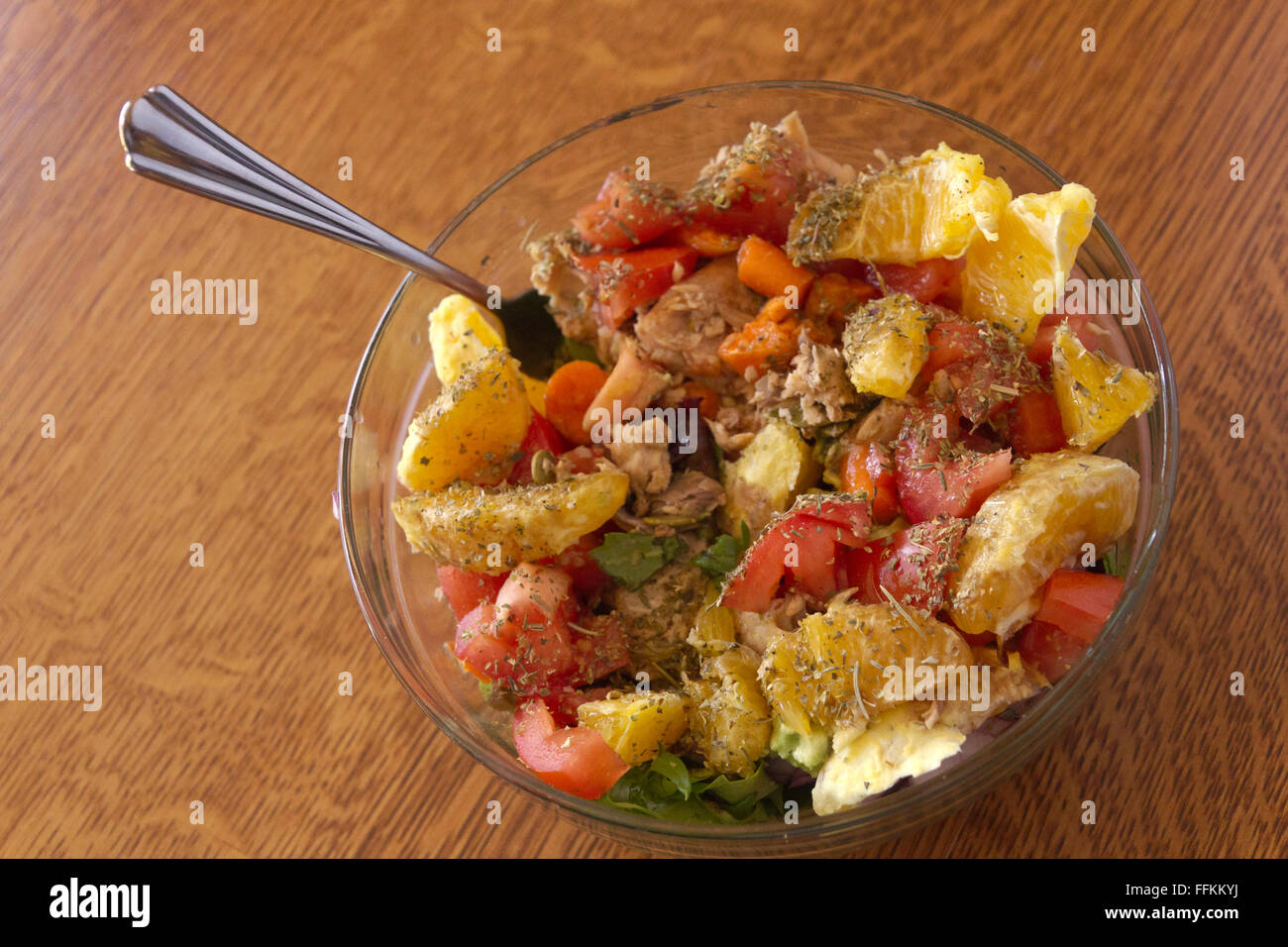 Nahaufnahme eines gesunden und kreativen Salat aus grünen, Tomaten, Lachs, Orangen, Avocado, Karotten, Kürbis Samen italienischen Dressing Stockfoto