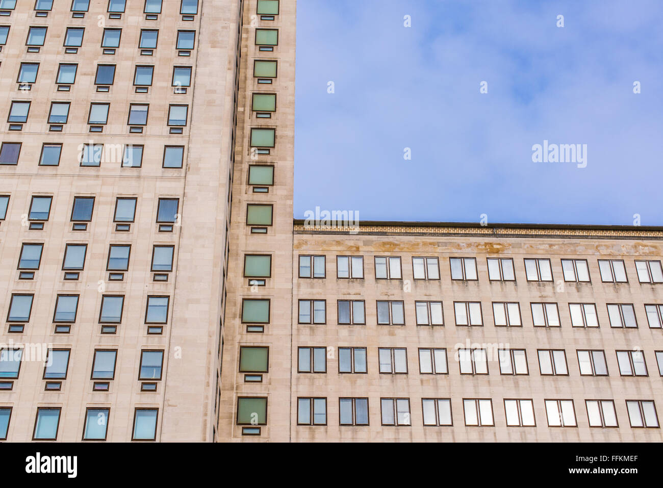Fassade eines großen mehrstöckigen Gebäude mit mehreren Fenstern und blauen Himmel im Hintergrund Stockfoto