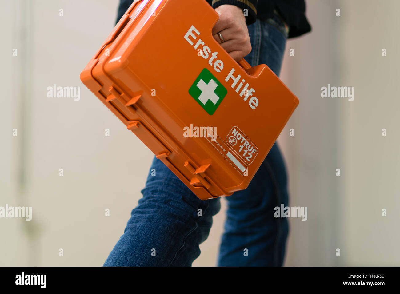 Erstversorgung nach einem Unfall bei der Arbeit. Ersthelfer mit erste-Hilfe-Kit, Deutschland. Stockfoto