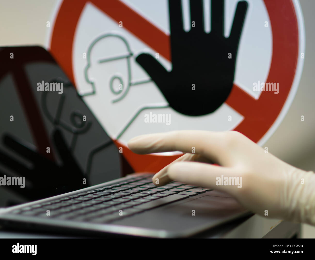 Männliche Hand mit Handschuh am Notebook. Konzept der Tinternet Verbrechen zu stoppen. Stockfoto