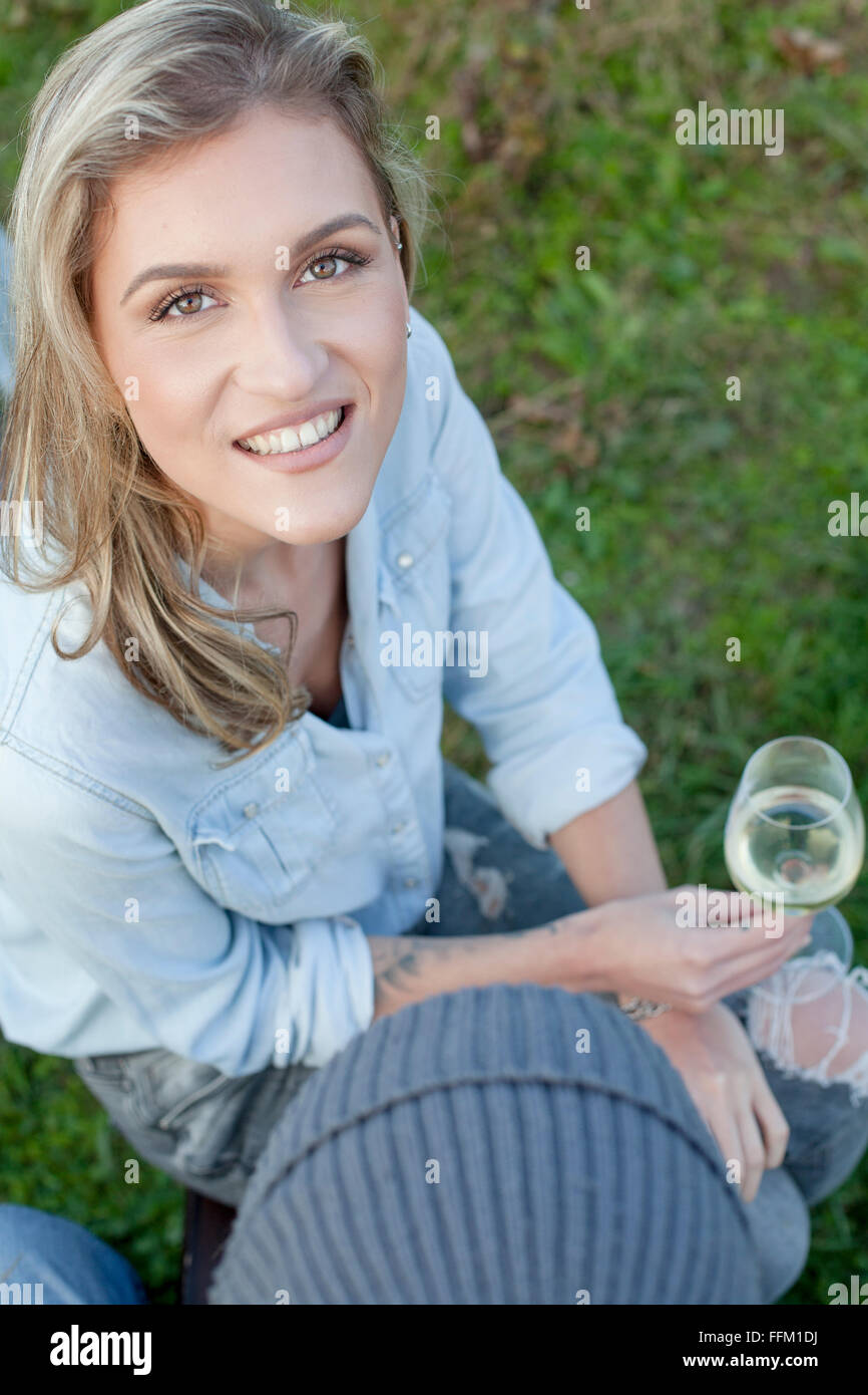 Frau mit blonden Haaren Weintrinken auf Gartenparty Stockfoto