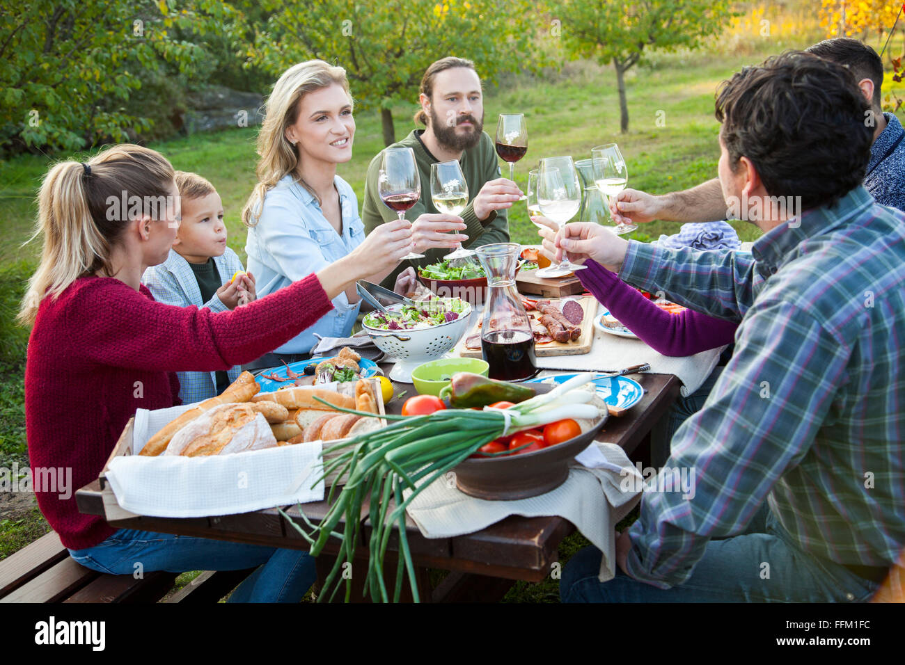 Gruppe von Freunden trinken Wein auf Gartenparty Stockfoto