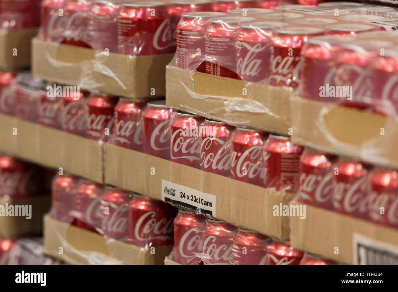 Dosen Coca Cola Cola in einem Lager gestapelt. Die Regierung soll die Einführung einer Steuer auf kohlensäurehaltige Getränke. Stockfoto