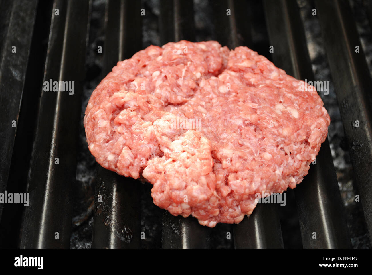 Rohe frische Hamburger auf einem Sommer-Grill Stockfoto