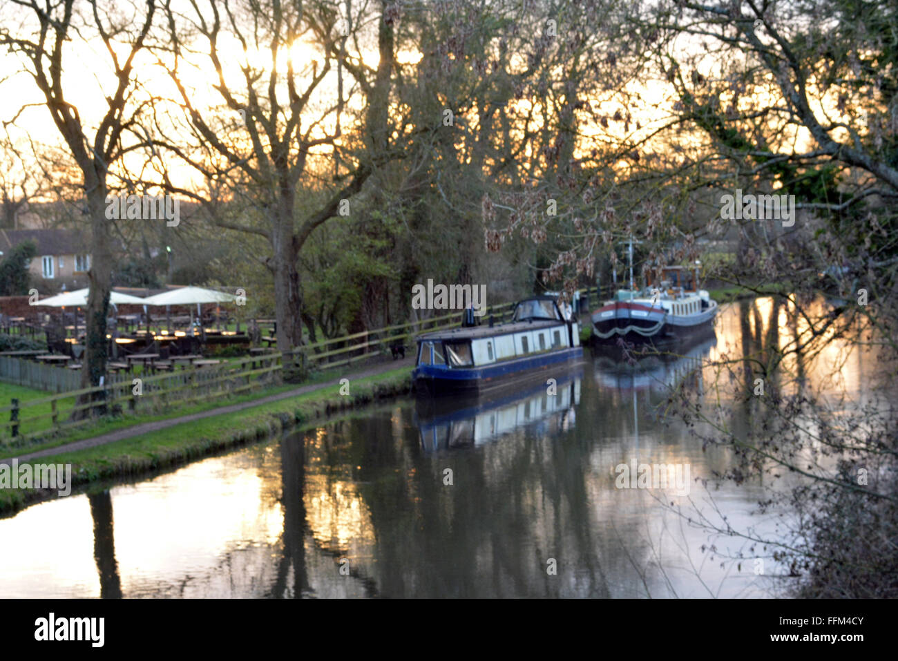 Canal fließt mit einem wunderschönen Sonnenuntergang hinter dem schlauen Mann, Burghfield, Reading, Berkshire, UK. Charles Dye / Alamy Live News Stockfoto