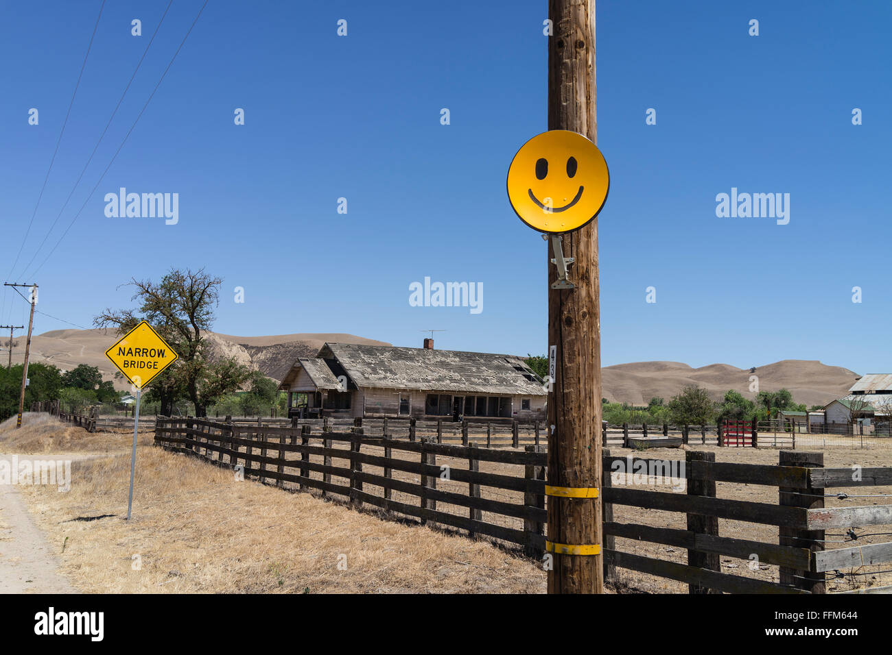 Eine gelblich orange Smiley Gesicht Satellitenantenne angebracht um eine Holzstange Telefon in Central Valley in Kalifornien. Stockfoto