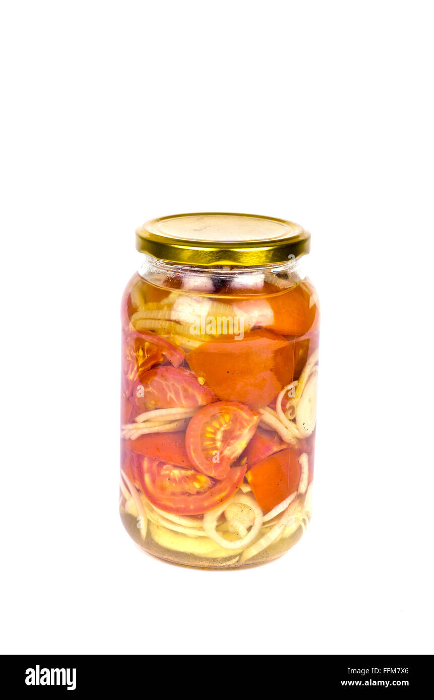 Tomaten aus der Dose rote halbiert und in Scheiben geschnittenen Zwiebeln, isoliert auf weiss in einem Glas Stockfoto