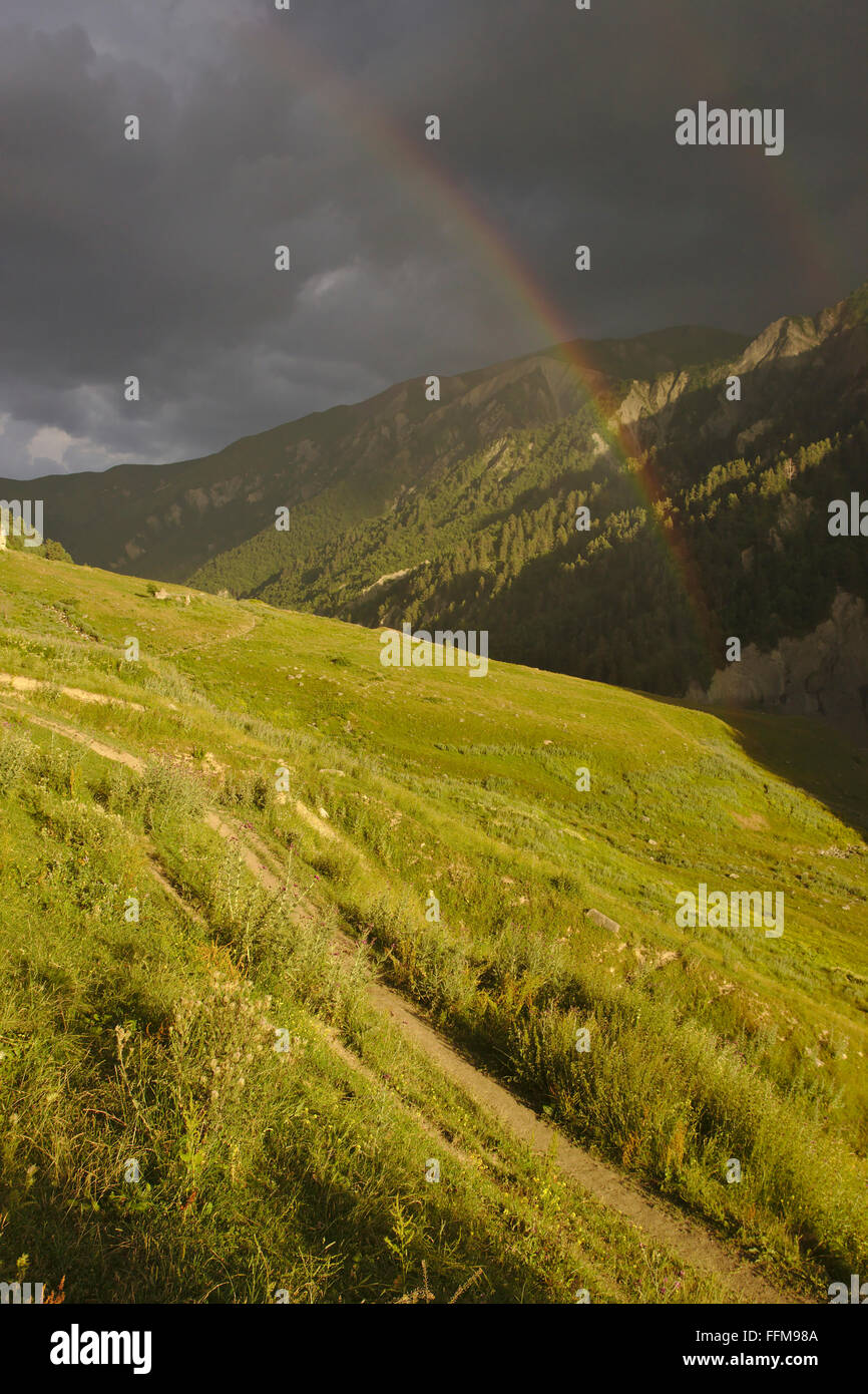 Abend Stimmung mit Regenbogen und dunkle Wolken im Tal des Adishi, obere Swanetien Mestia Ushguli Trek, Georgia Stockfoto