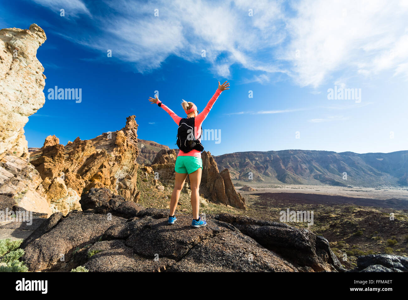 Frau Wanderer mit ausgestreckten in Bergen. Weibliche Schönheit Läufer, Hände hoch und genießen Sie inspirierende Landschaft auf felsigen Pfad Stockfoto