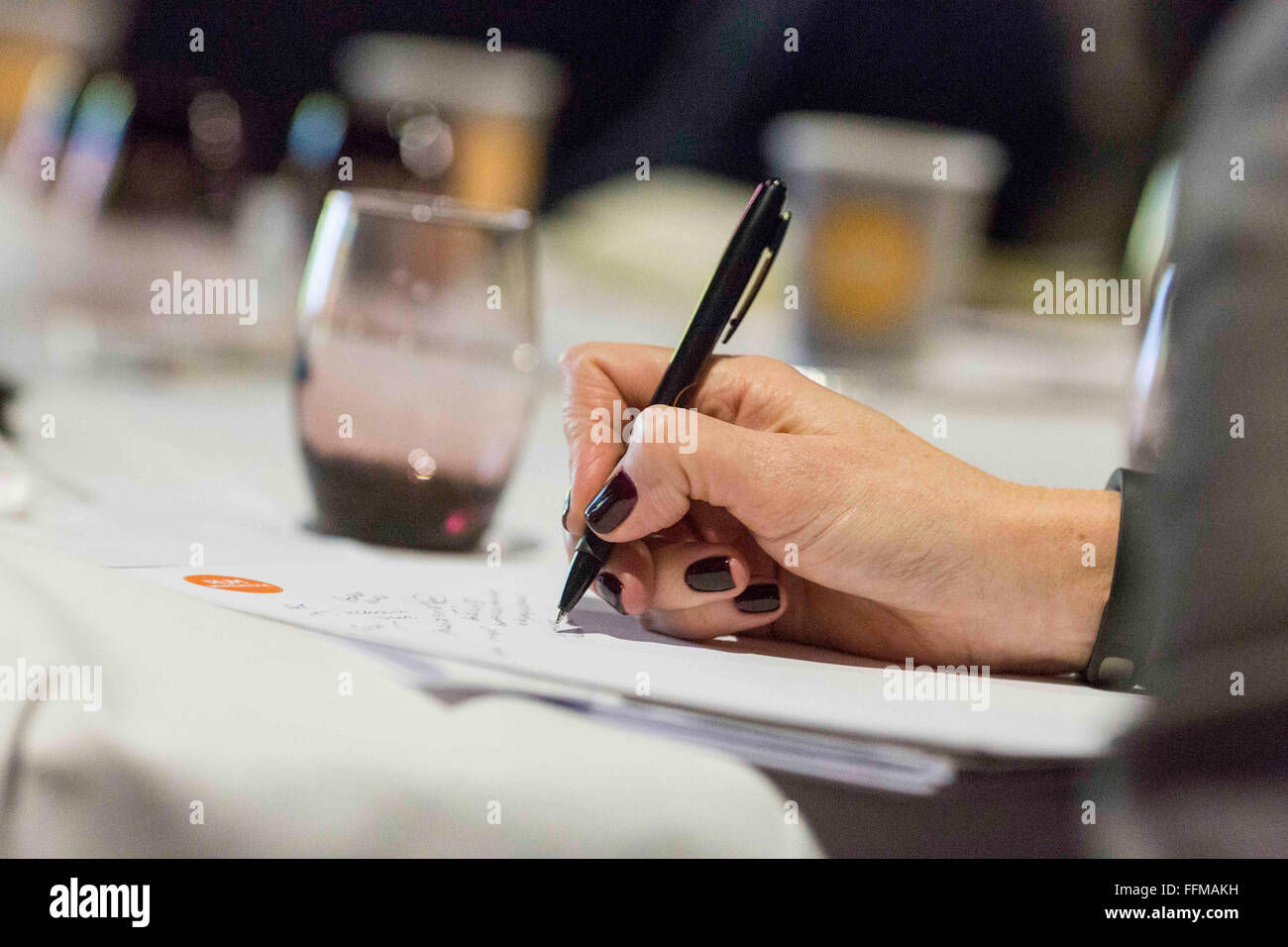 eine Frau macht sich Notizen während einer Konferenz Stockfoto