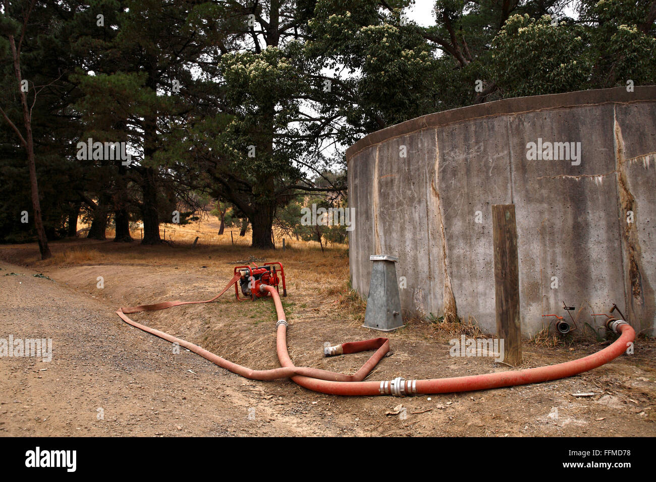 Konkrete Vorratsbehälter für Wasser mit Pumpe und Schläuchen, Victoria Australien Stockfoto